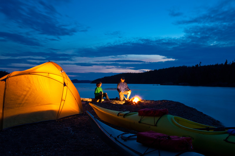 Un couple fait du camping dans l’arrière-pays au coucher du soleil, en été, sur l’île Seal, dans le parc national Terra-Nova / Couple backcountry camping in summer at sunset on Seal Island, in Terra Nova National Park